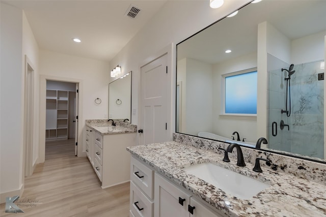 bathroom featuring shower with separate bathtub, hardwood / wood-style floors, and vanity