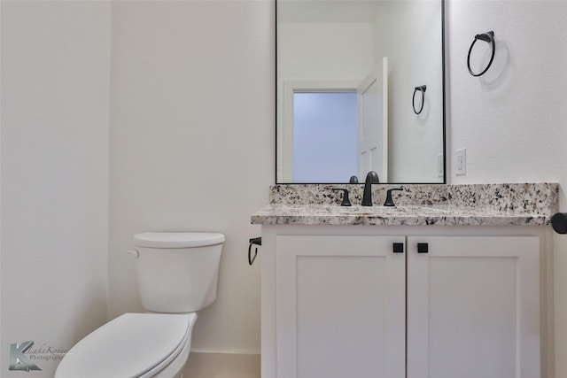 half bath featuring toilet and vanity