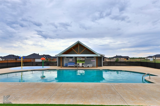 pool with a fenced backyard and a patio