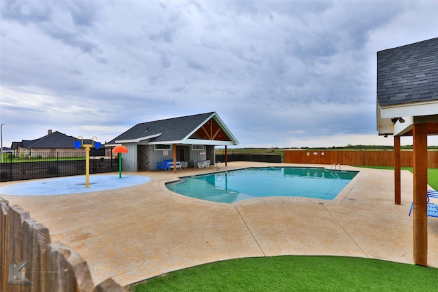 pool with a patio area and a fenced backyard