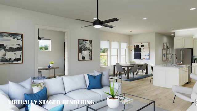 living room with ceiling fan, a wealth of natural light, light hardwood / wood-style flooring, and sink