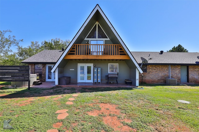 rear view of property with a patio area, central air condition unit, french doors, and a yard