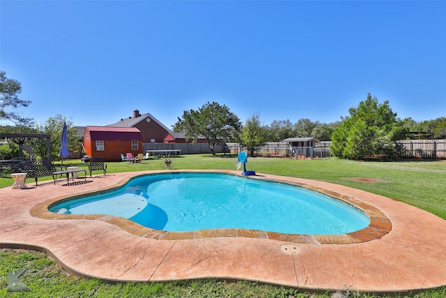 view of pool with a yard, a storage shed, and a patio