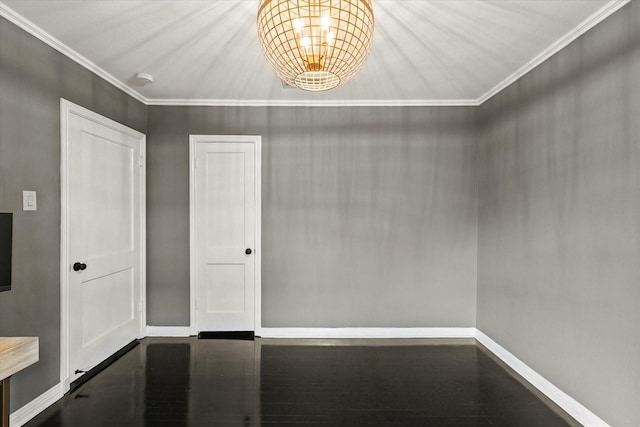 empty room featuring wood-type flooring, a chandelier, and ornamental molding