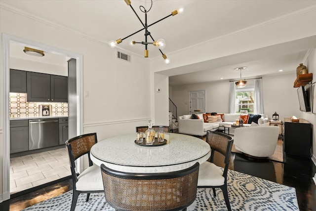 dining room featuring light tile patterned floors, crown molding, and a notable chandelier