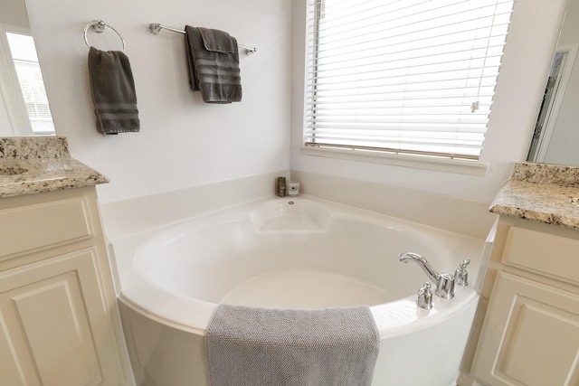 bathroom featuring vanity and a bath