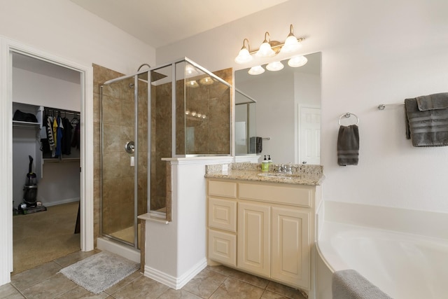 bathroom with tile patterned flooring, shower with separate bathtub, and vanity