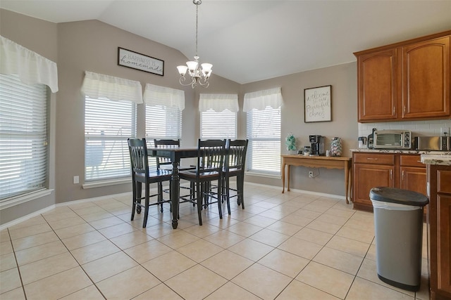 dining area with an inviting chandelier, lofted ceiling, and light tile patterned floors