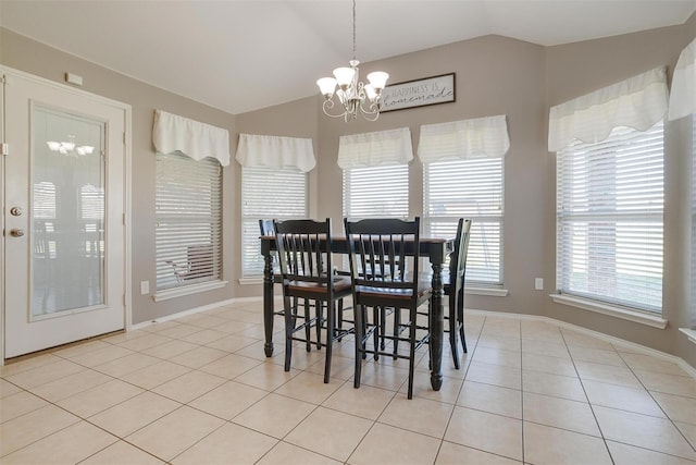 dining space with lofted ceiling, a notable chandelier, and light tile patterned flooring