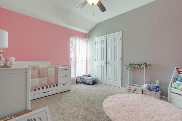 bedroom with a nursery area, lofted ceiling, light colored carpet, ceiling fan, and a closet