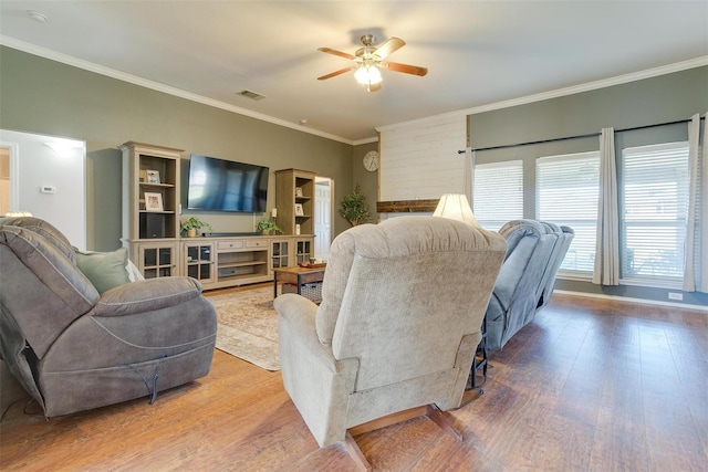 living room with hardwood / wood-style flooring, ceiling fan, and ornamental molding