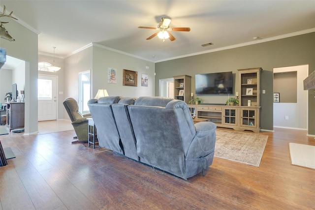 living room featuring wood-type flooring, ornamental molding, and ceiling fan