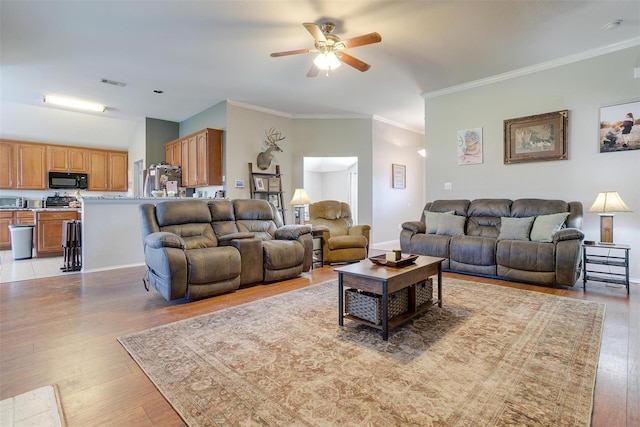 living room featuring crown molding, ceiling fan, and light hardwood / wood-style floors