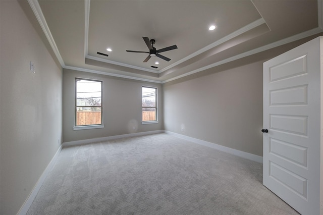 empty room featuring light carpet, ornamental molding, a raised ceiling, and ceiling fan