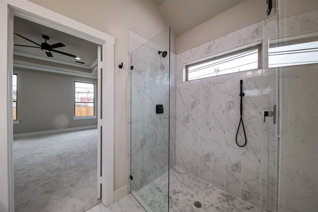 bathroom with ornamental molding, tiled shower, ceiling fan, and a tray ceiling