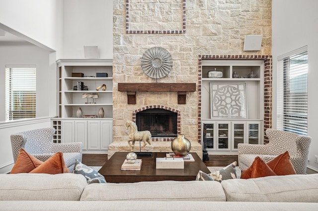 living room featuring wood-type flooring and a stone fireplace