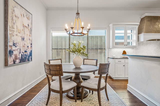 dining area with dark hardwood / wood-style floors, ornamental molding, a chandelier, and a healthy amount of sunlight