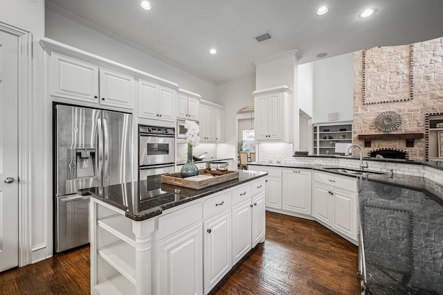 kitchen with a center island, white cabinetry, stainless steel appliances, sink, and dark hardwood / wood-style floors