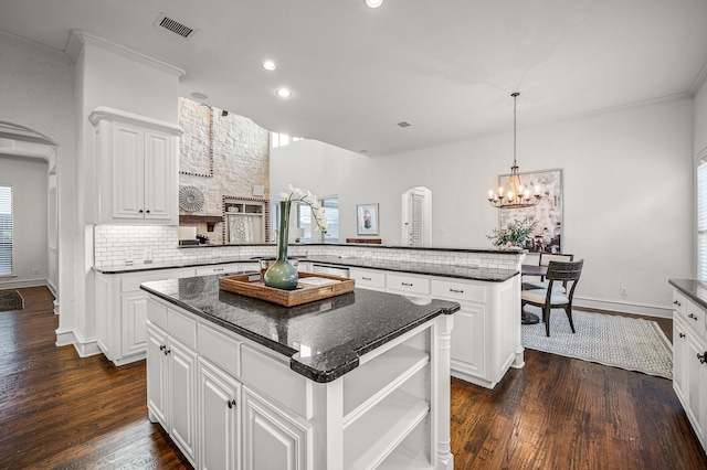 kitchen with dark wood-type flooring, white cabinets, and a center island