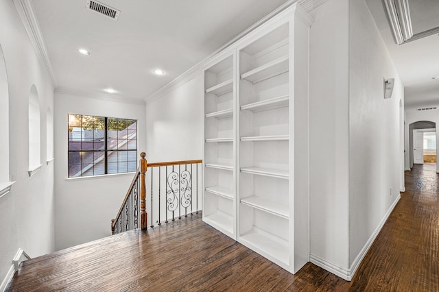 hallway featuring crown molding, built in features, and dark hardwood / wood-style floors