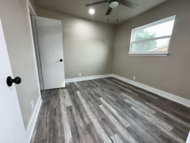 empty room with ceiling fan and dark hardwood / wood-style flooring