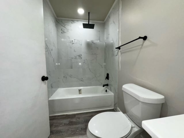 bathroom featuring toilet, tiled shower / bath combo, and hardwood / wood-style floors