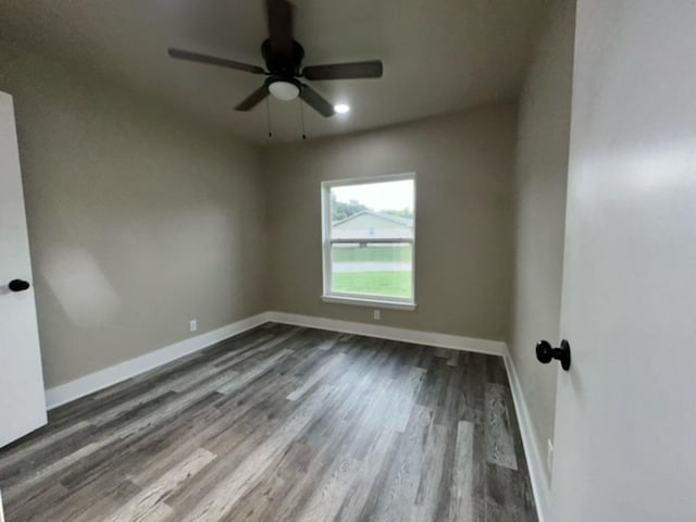 empty room with ceiling fan and dark hardwood / wood-style flooring