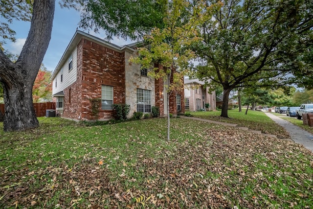 view of front of house with a front yard and cooling unit