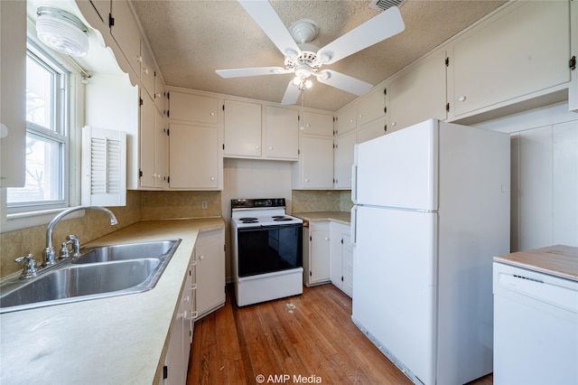 2025 Avenue Ave N, Anson, TX 79501 - kitchen featuring white appliances, white cabinets, wood-type flooring, sink, and backsplash