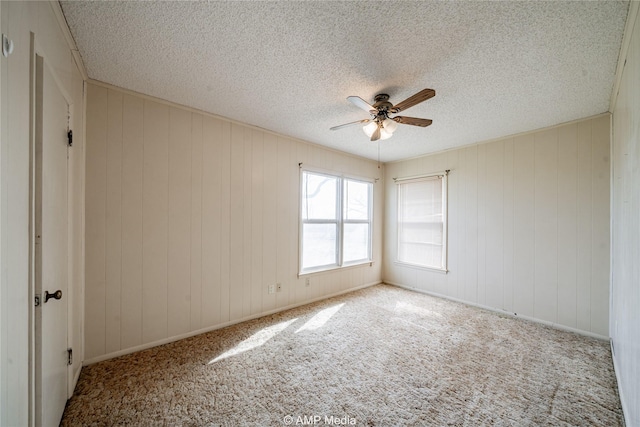 2025 Avenue Ave N, Anson, TX 79501 - carpeted empty room with ceiling fan, a textured ceiling, and wood walls