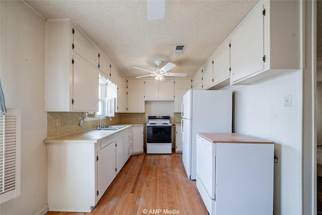 2025 Avenue Ave N, Anson, TX 79501 - kitchen with light hardwood / wood-style floors, white appliances, a textured ceiling, white cabinets, and sink