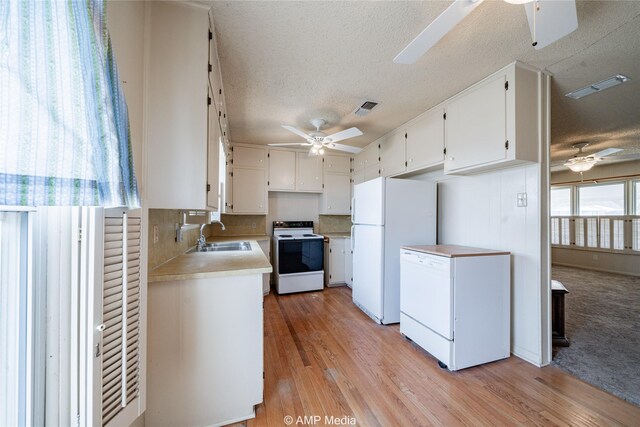 2025 Avenue Ave N, Anson, TX 79501 - kitchen with light hardwood / wood-style floors, white appliances, a textured ceiling, white cabinets, and sink