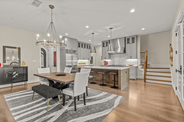 dining space featuring sink, a chandelier, and light hardwood / wood-style flooring