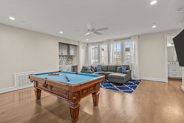 game room featuring beverage cooler, light hardwood / wood-style floors, billiards, bar, and ceiling fan