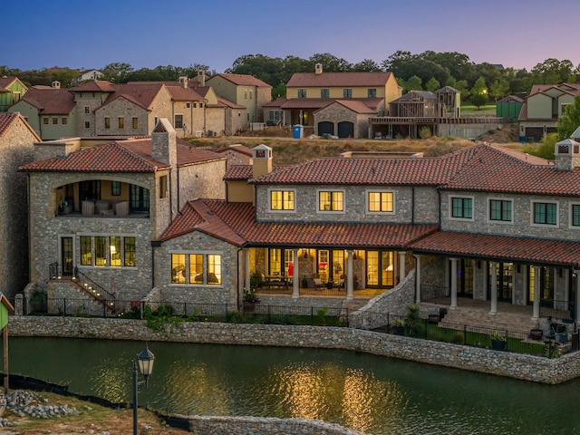 back house at dusk with a water view