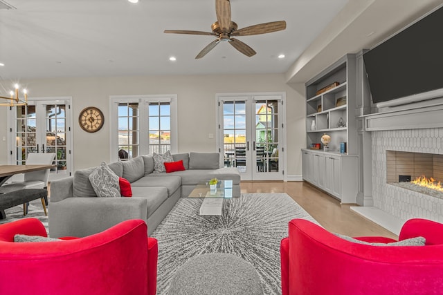 living room with ceiling fan, built in features, and french doors