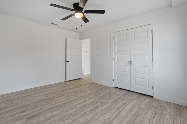 unfurnished bedroom featuring light hardwood / wood-style floors, ceiling fan, and a closet