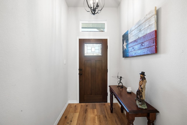 foyer entrance with an inviting chandelier and hardwood / wood-style flooring