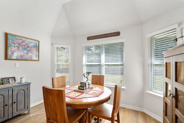 dining room with lofted ceiling and light hardwood / wood-style floors