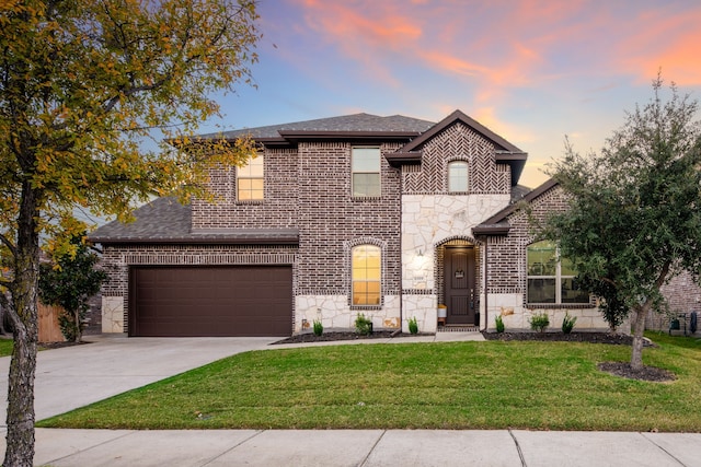 view of front of home with a garage and a yard