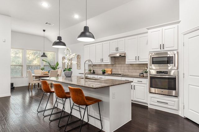 kitchen featuring pendant lighting, sink, white cabinetry, a kitchen island with sink, and appliances with stainless steel finishes