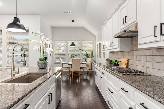 kitchen with pendant lighting, white cabinets, appliances with stainless steel finishes, dark hardwood / wood-style flooring, and sink