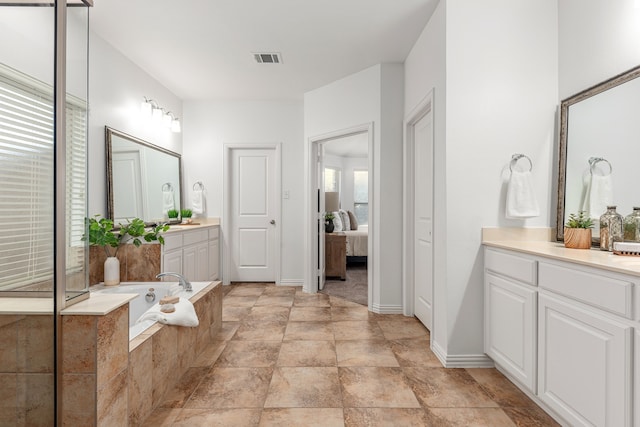 bathroom with tiled bath and vanity