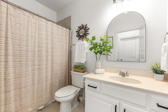 bathroom featuring toilet, vanity, a shower with curtain, and tile patterned flooring