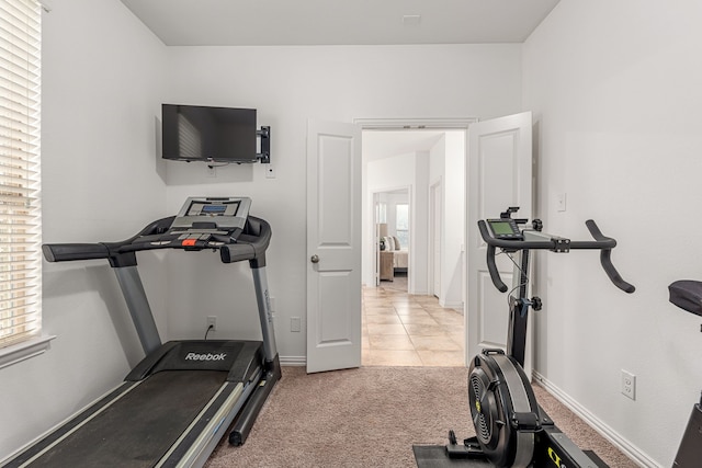 workout room featuring light carpet