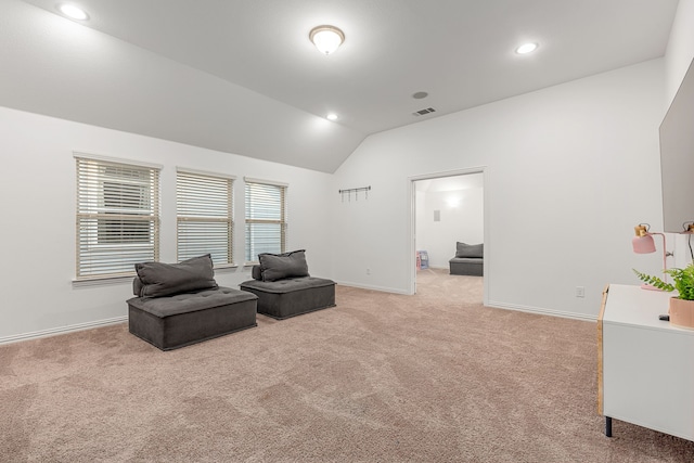 living area with lofted ceiling and light colored carpet