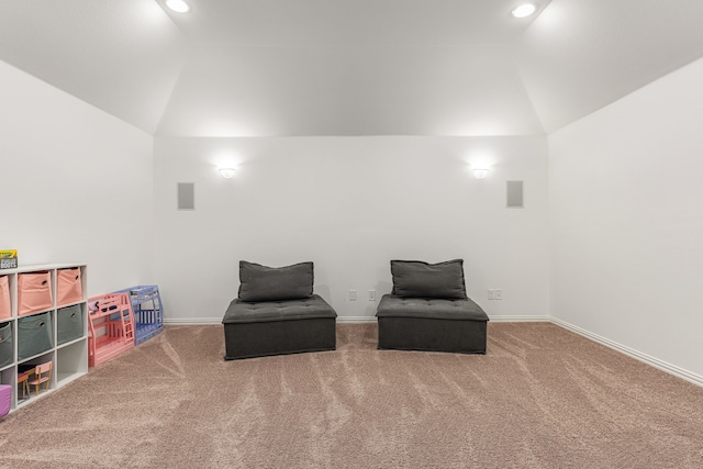 sitting room with vaulted ceiling and carpet floors