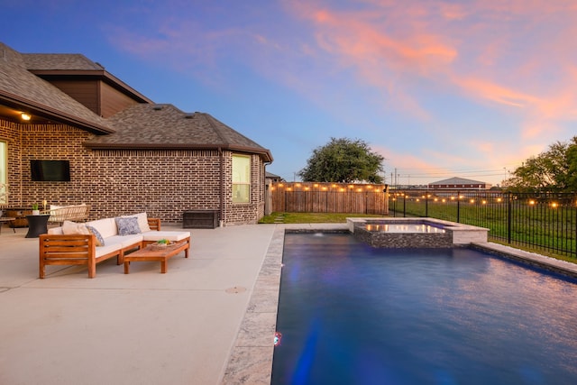 pool at dusk featuring an outdoor hangout area, a patio area, and an in ground hot tub