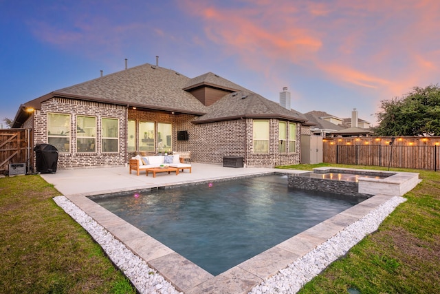 pool at dusk with area for grilling, an in ground hot tub, a patio, a yard, and an outdoor hangout area