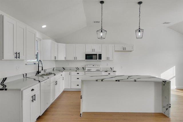 kitchen featuring decorative light fixtures, a center island, sink, white appliances, and white cabinetry